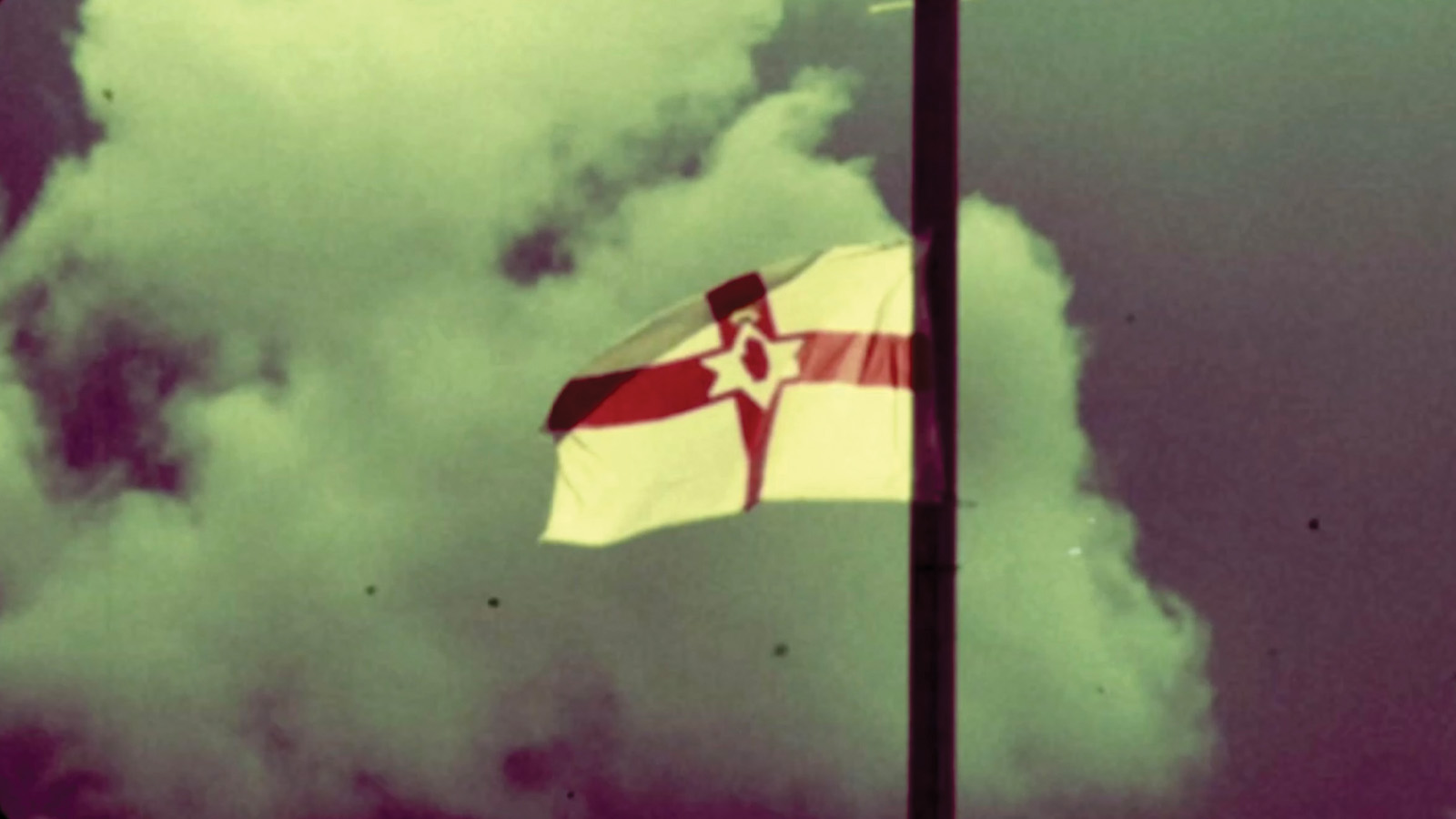 Closing Film, The Irish Question movie still showing a flag blowing in the wind surrounded by clouds.